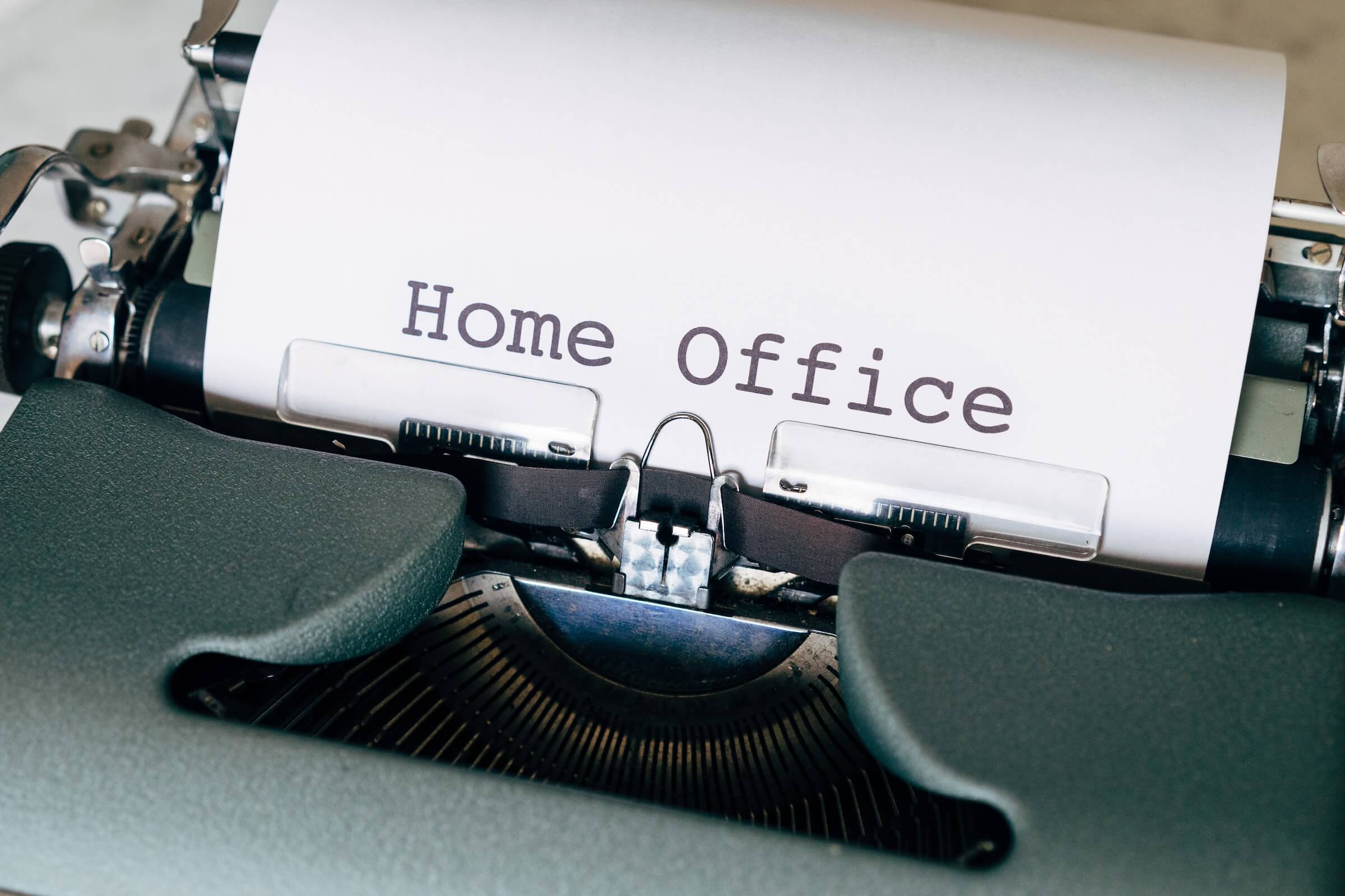 Blatt Papier mit Aufschrift "Home Office" kommt aus Schreibmaschine